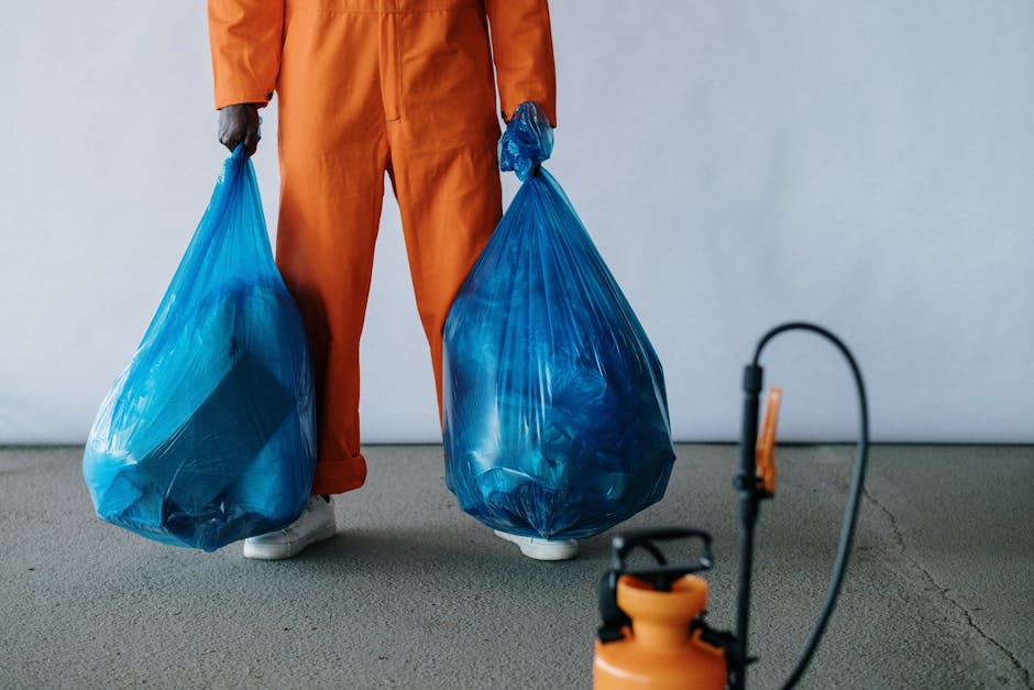 A person using a red vacuum cleaner on a textured beige carpet in a living room or hallway. The vacuum is positioned upright, with the cleaning head on the carpet, and the person's bare feet are visib